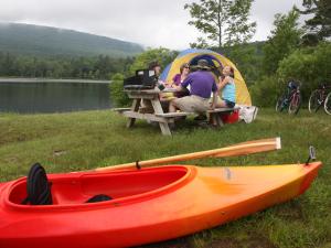 A kayak and tent on the shore of North South Lake with a family sitting at a picnic table