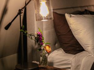 Night stand with vintage glass and iron desk lamp next to the bed at the Long Neck Inn