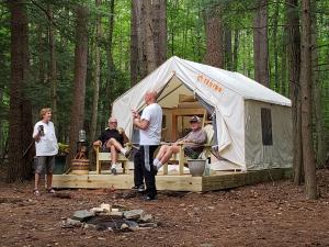 people gathered around a Purling waters canvas glamping tent