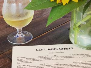 glass of hard cider next to a flower and menu