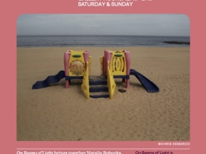 A postcard with a picture of a play set on the beach