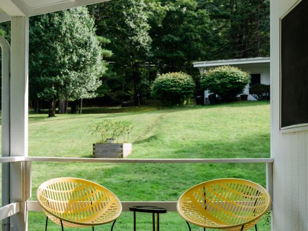 Two chairs on wooden porch with yard in background