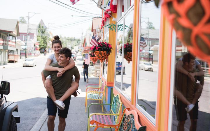 Couple with girl on mans back walking down main street Tannersville