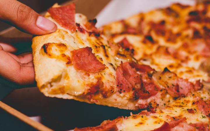 slice of pizza being pulled from a full pie